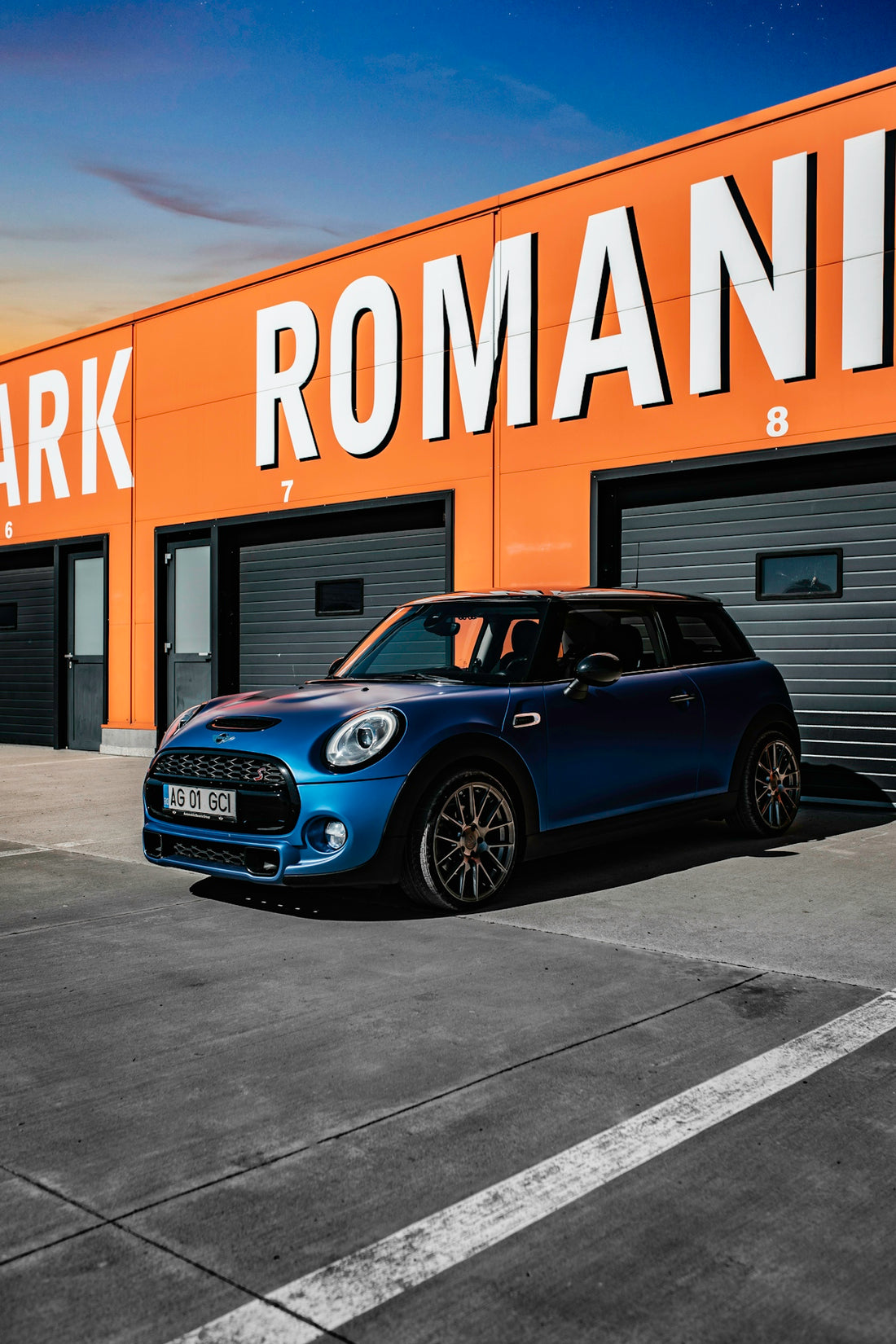 Blue mini cooper parked in front of orange building