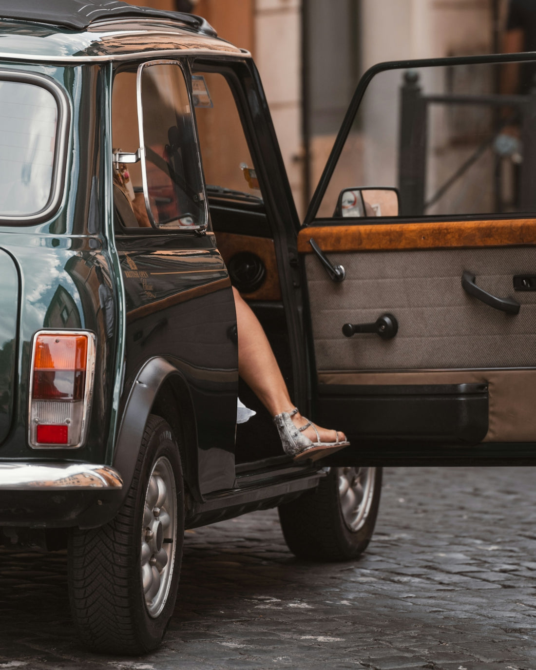 A woman sitting in the back of a green car