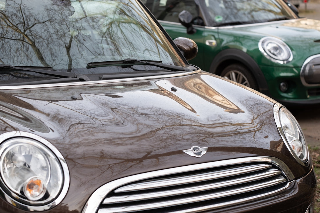 Two mini coopers, one brown and one green.