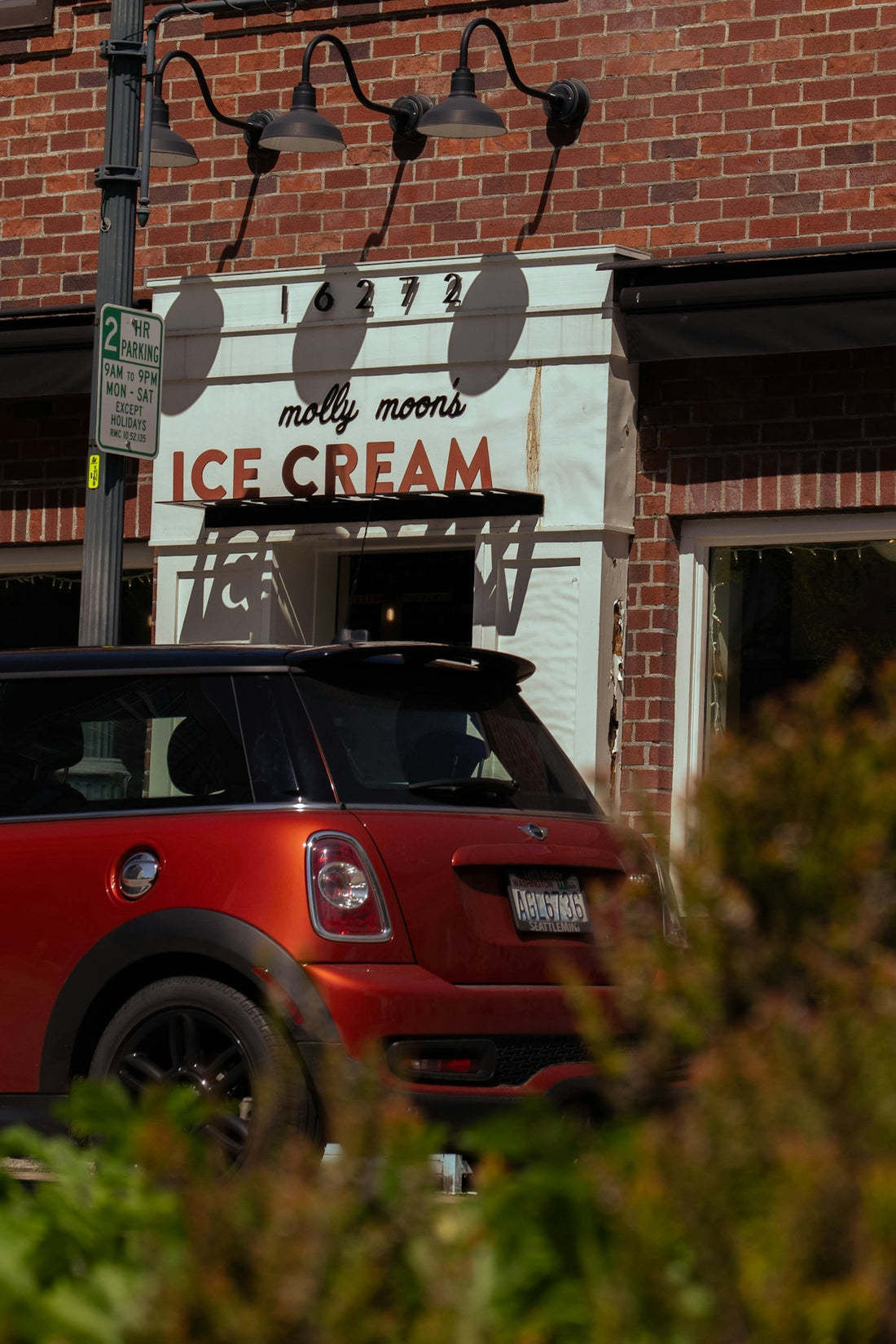 Red mini cooper parked outside molly moons ice cream.
