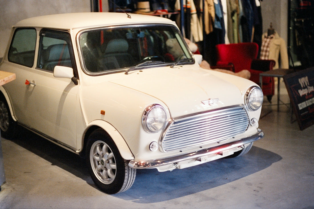 A classic white mini cooper parked indoors.