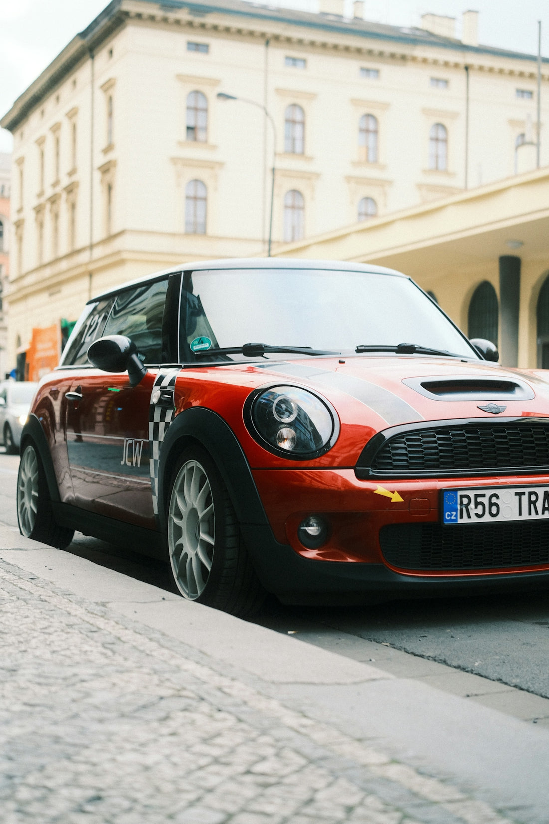 Orange mini cooper parked on a city street.